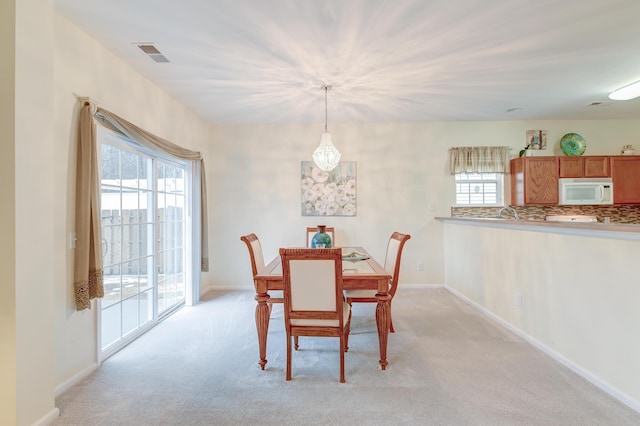 dining space featuring light carpet