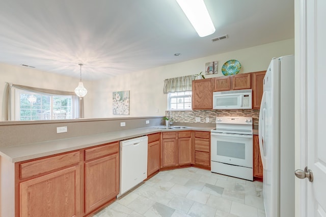 kitchen featuring sink, white appliances, backsplash, decorative light fixtures, and kitchen peninsula