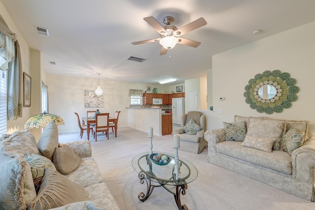 living room with ceiling fan and light colored carpet