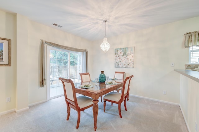 dining space featuring light colored carpet and a healthy amount of sunlight