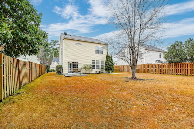 back of house with a yard and a patio