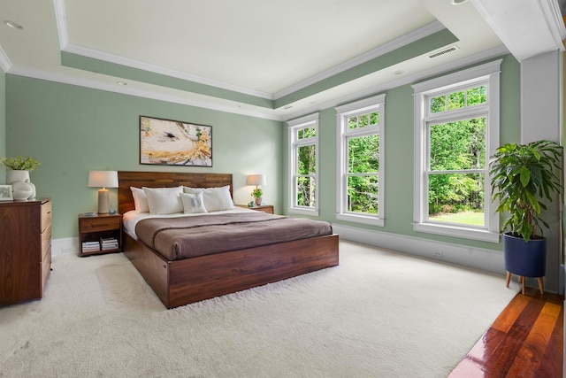 bedroom featuring a raised ceiling, ornamental molding, carpet, and visible vents
