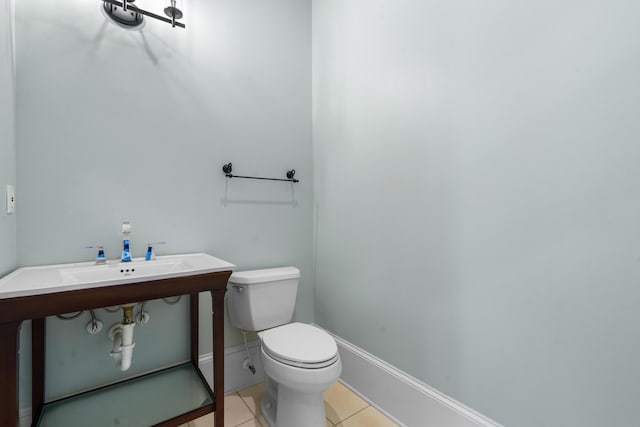 half bathroom featuring tile patterned floors, baseboards, and toilet