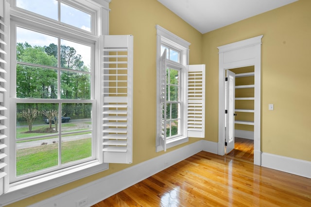 entryway with a wealth of natural light, baseboards, and wood finished floors