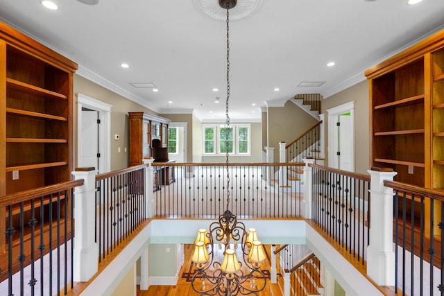 corridor with ornamental molding, an upstairs landing, and recessed lighting