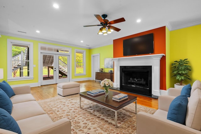 living area with crown molding, wood finished floors, a ceiling fan, and recessed lighting