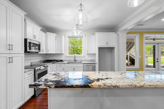 kitchen featuring ornamental molding, white cabinetry, backsplash, appliances with stainless steel finishes, and a sink