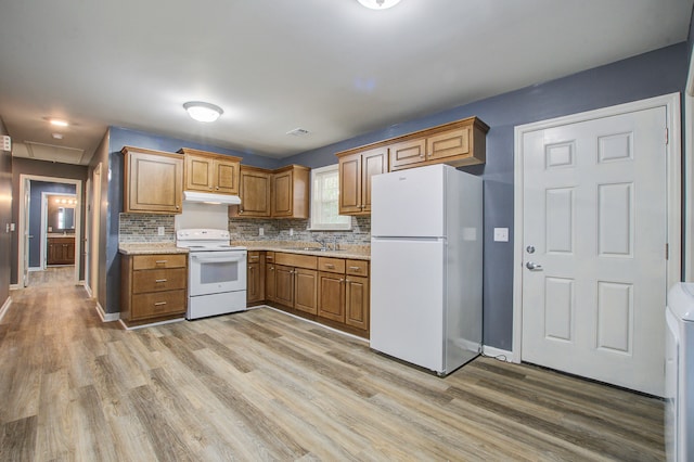 kitchen featuring decorative backsplash, light hardwood / wood-style flooring, white appliances, and sink