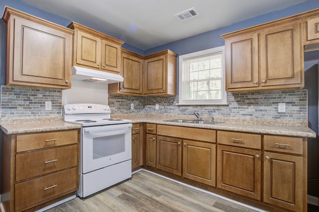 kitchen with decorative backsplash, light hardwood / wood-style flooring, white range with electric stovetop, and sink