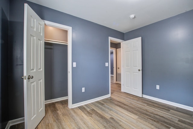 unfurnished bedroom with hardwood / wood-style flooring and a closet