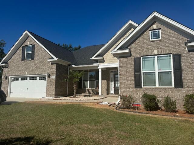 craftsman-style home featuring a front lawn and a garage