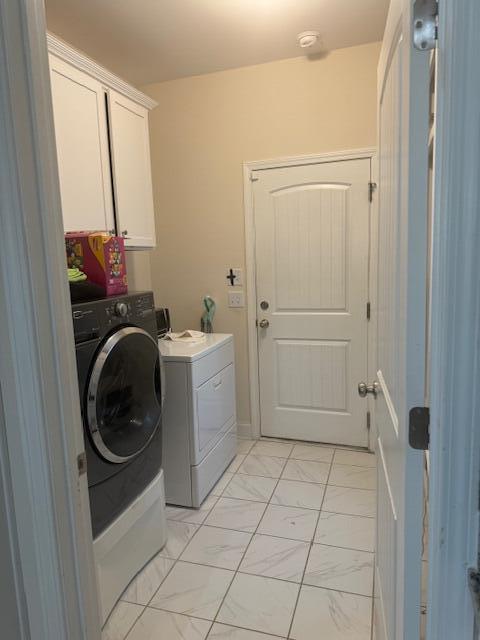 laundry room with washer and clothes dryer and cabinets