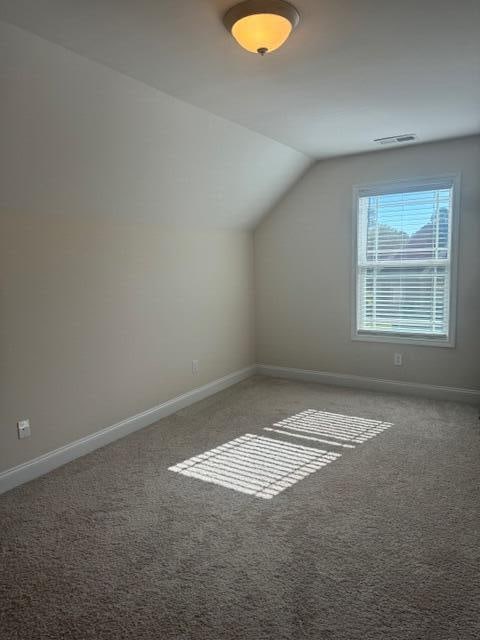 bonus room featuring carpet flooring and vaulted ceiling