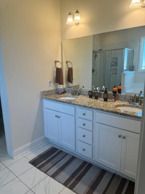 bathroom with a shower with door and vanity