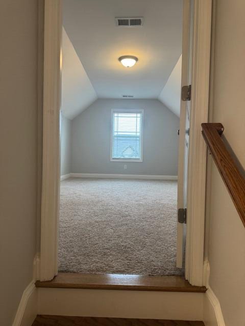 bonus room featuring carpet floors and vaulted ceiling