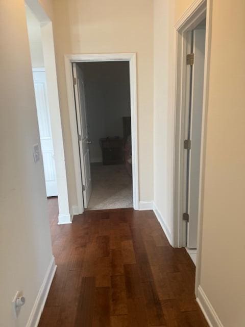 corridor with dark hardwood / wood-style flooring