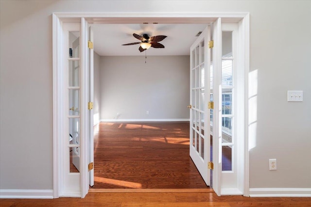 corridor with wood-type flooring and french doors