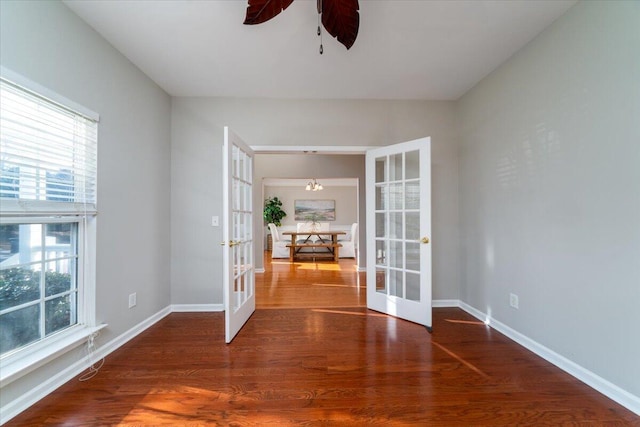 empty room featuring wood-type flooring, french doors, and ceiling fan