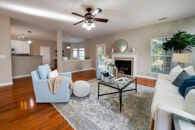 living room with dark wood-type flooring and ceiling fan