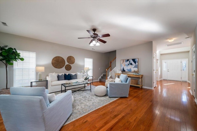 living room with dark wood-type flooring and ceiling fan