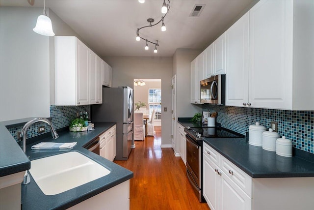 kitchen featuring sink, hanging light fixtures, white cabinets, and appliances with stainless steel finishes