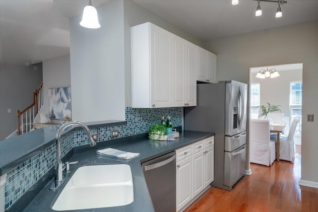 kitchen with sink, decorative light fixtures, stainless steel appliances, and white cabinets