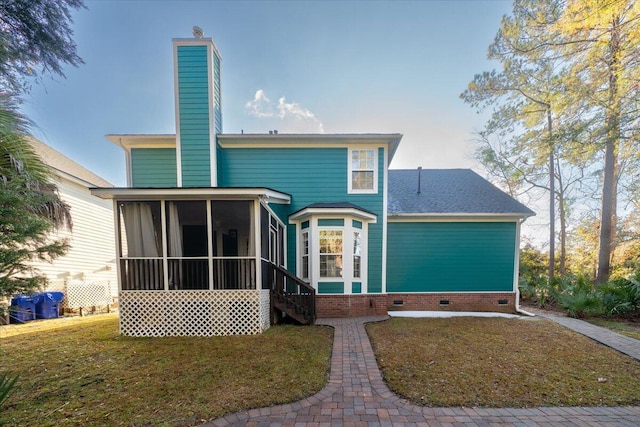 back of property with a sunroom and a yard