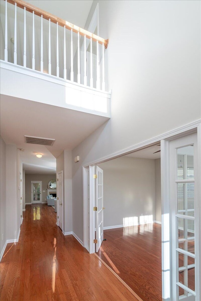 corridor featuring a high ceiling and hardwood / wood-style floors