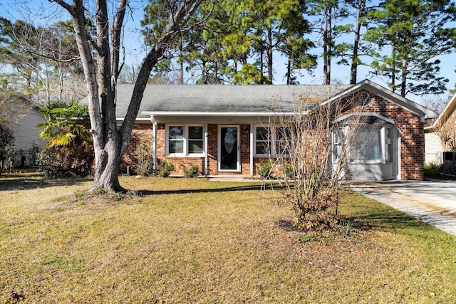 single story home with a front lawn, a garage, brick siding, and driveway