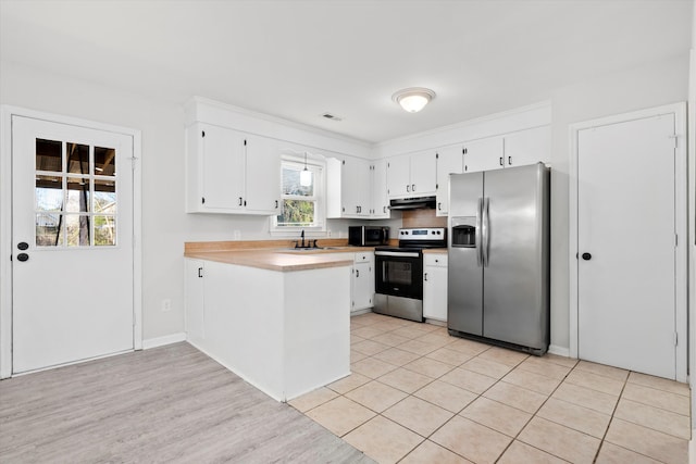 kitchen featuring under cabinet range hood, appliances with stainless steel finishes, white cabinetry, and a peninsula