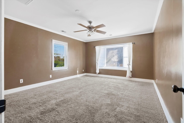 carpeted empty room with a ceiling fan, visible vents, baseboards, and ornamental molding