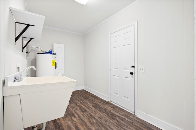 washroom with electric water heater, crown molding, baseboards, dark wood finished floors, and a sink