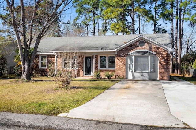 ranch-style house featuring driveway, brick siding, and a front yard