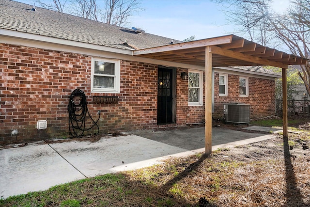 back of property with a patio area, central AC unit, and brick siding