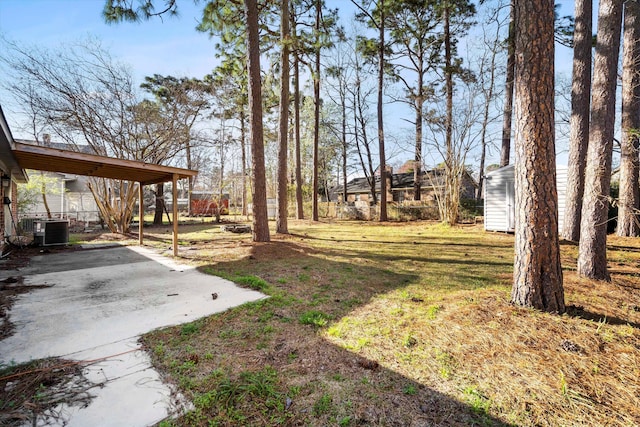 view of yard featuring an outbuilding, central AC unit, and a carport