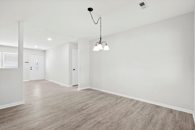 empty room with wood finished floors, visible vents, baseboards, recessed lighting, and a chandelier