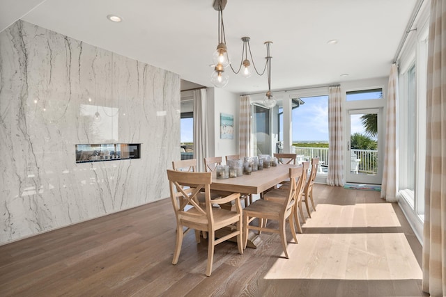 dining area featuring a fireplace, a chandelier, and hardwood / wood-style floors