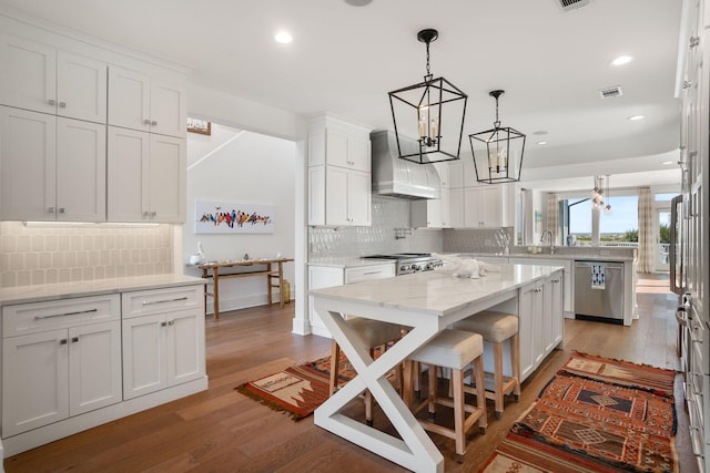 kitchen with hardwood / wood-style flooring, tasteful backsplash, wall chimney range hood, and white cabinets