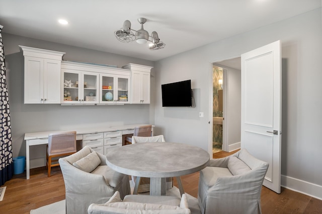 dining room with built in desk and dark hardwood / wood-style flooring