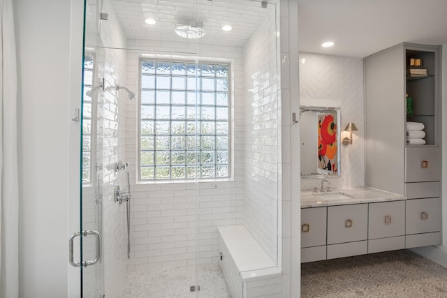 bathroom featuring walk in shower, vanity, and a wealth of natural light