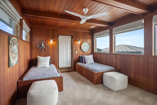 carpeted bedroom featuring wooden ceiling, beam ceiling, and wooden walls