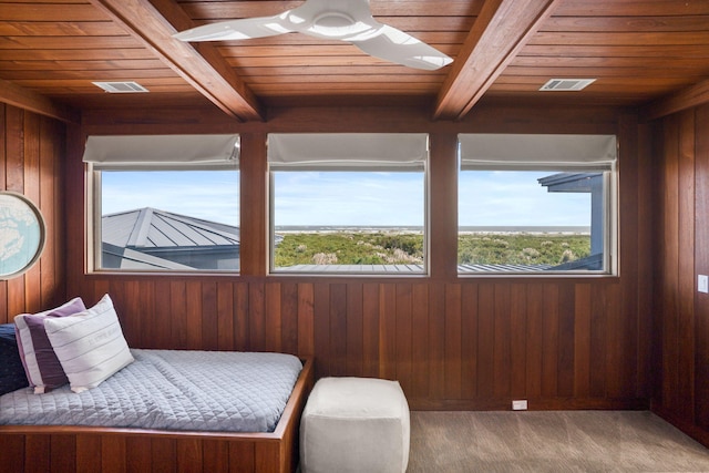 sitting room featuring beam ceiling, wooden ceiling, and a healthy amount of sunlight