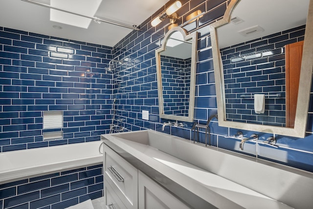 bathroom with vanity, tile walls, and tiled shower / bath combo