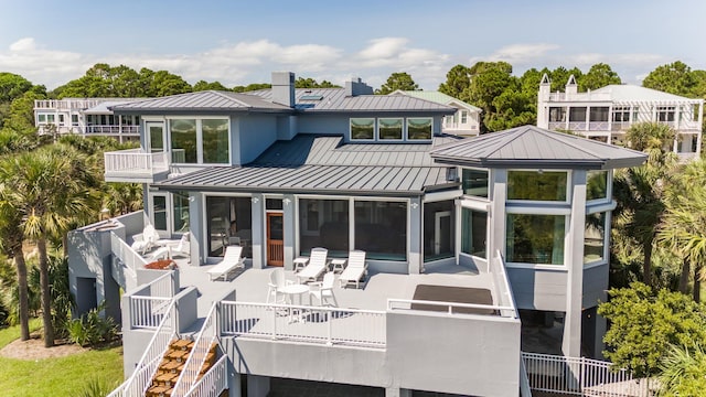 back of property featuring a balcony and a sunroom