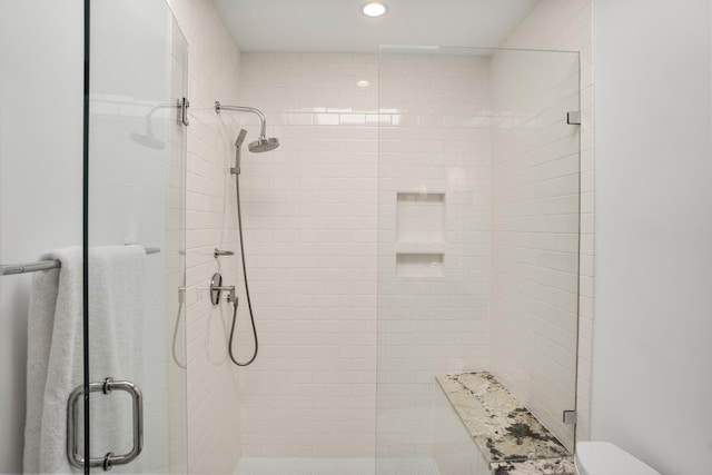 bathroom with a shower with door and toilet