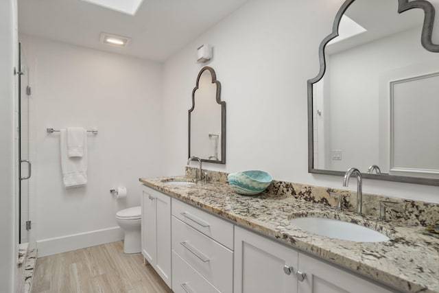 bathroom with an enclosed shower, hardwood / wood-style flooring, vanity, and toilet