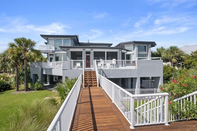 back of property featuring a yard and a sunroom