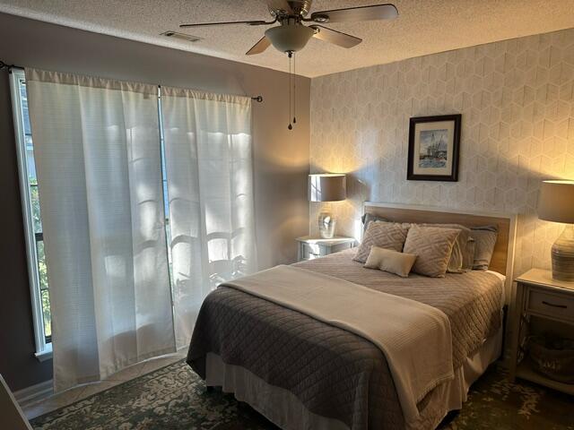 bedroom with a textured ceiling and ceiling fan