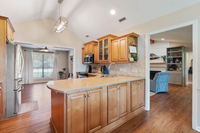 kitchen featuring dark hardwood / wood-style flooring, stainless steel appliances, pendant lighting, and vaulted ceiling