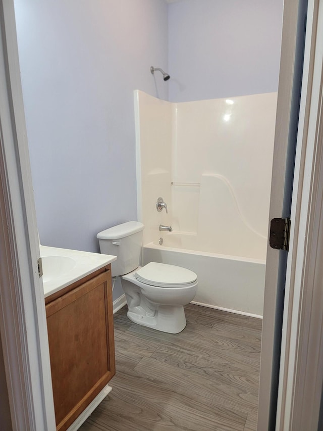 full bathroom featuring vanity, hardwood / wood-style floors,  shower combination, and toilet